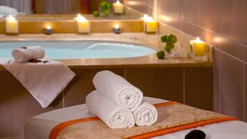 Relax in a serene spa area with a large bathtub and massage table, perfect for unwinding.