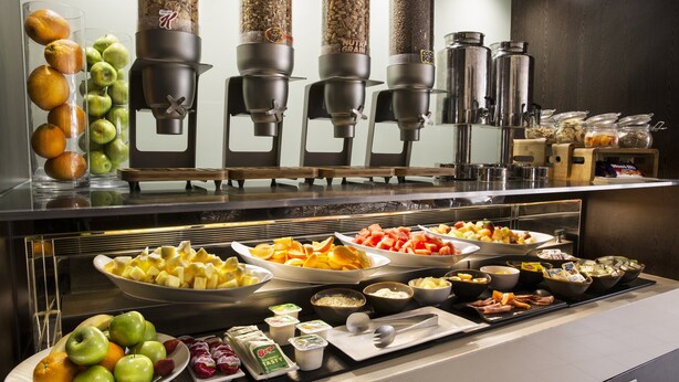 A buffet with various food items and a coffee station.