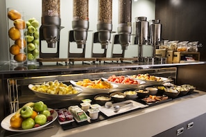 Un bufé con diferentes opciones de comida y una estación de café.