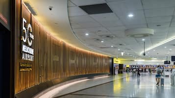 Una terminal aeroportuaria espaciosa con una pared curva que muestra un letrero de celebración por 5 años.