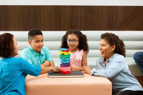 A group of people sitting on a couch with a stack of colorful blocks in front of them.