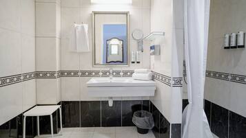 Un baño con un lavamanos blanco, un espejo y baldosas de mármol negro.