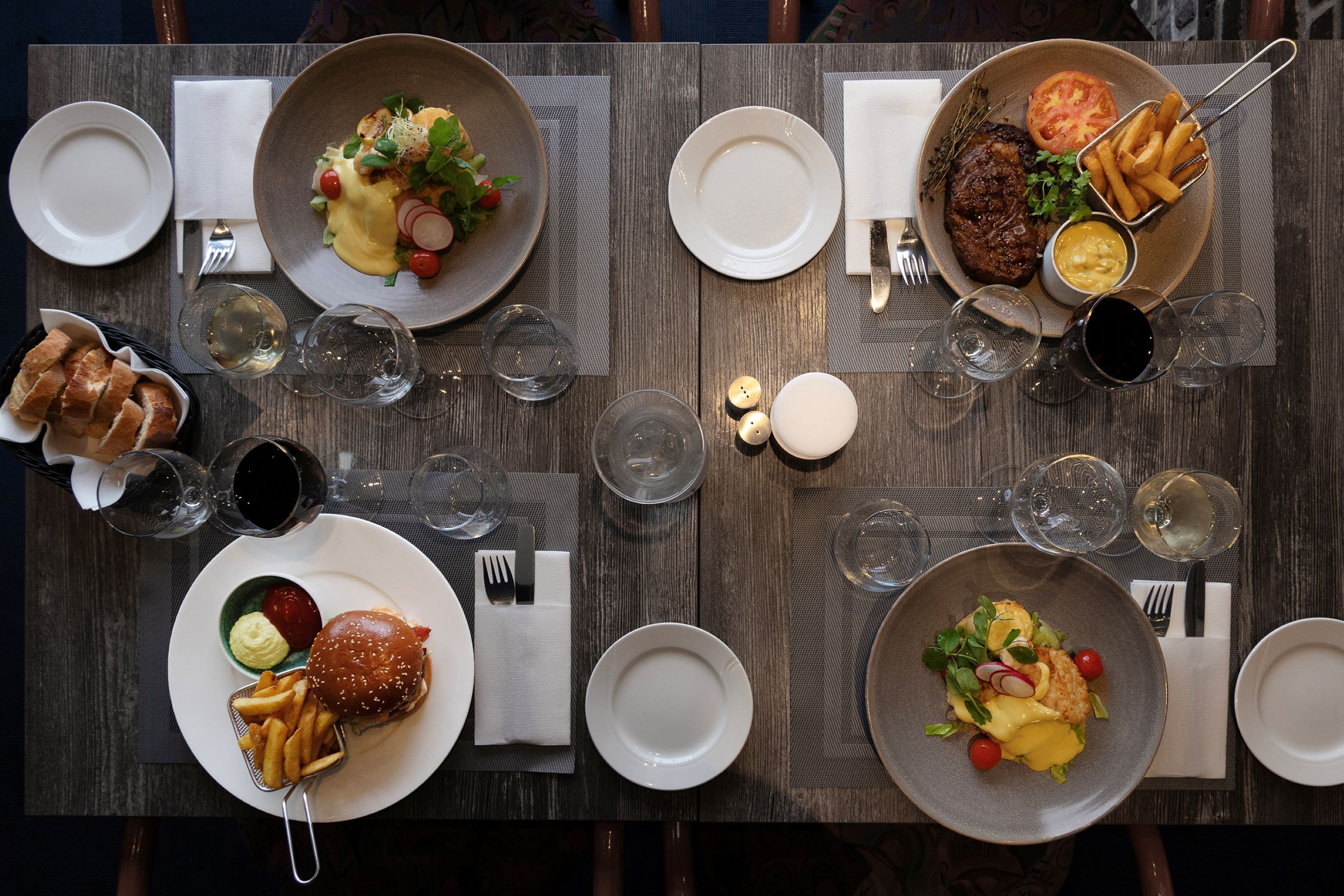 A dining table set with various dishes, glasses, and cutlery, indicating a restaurant setting.