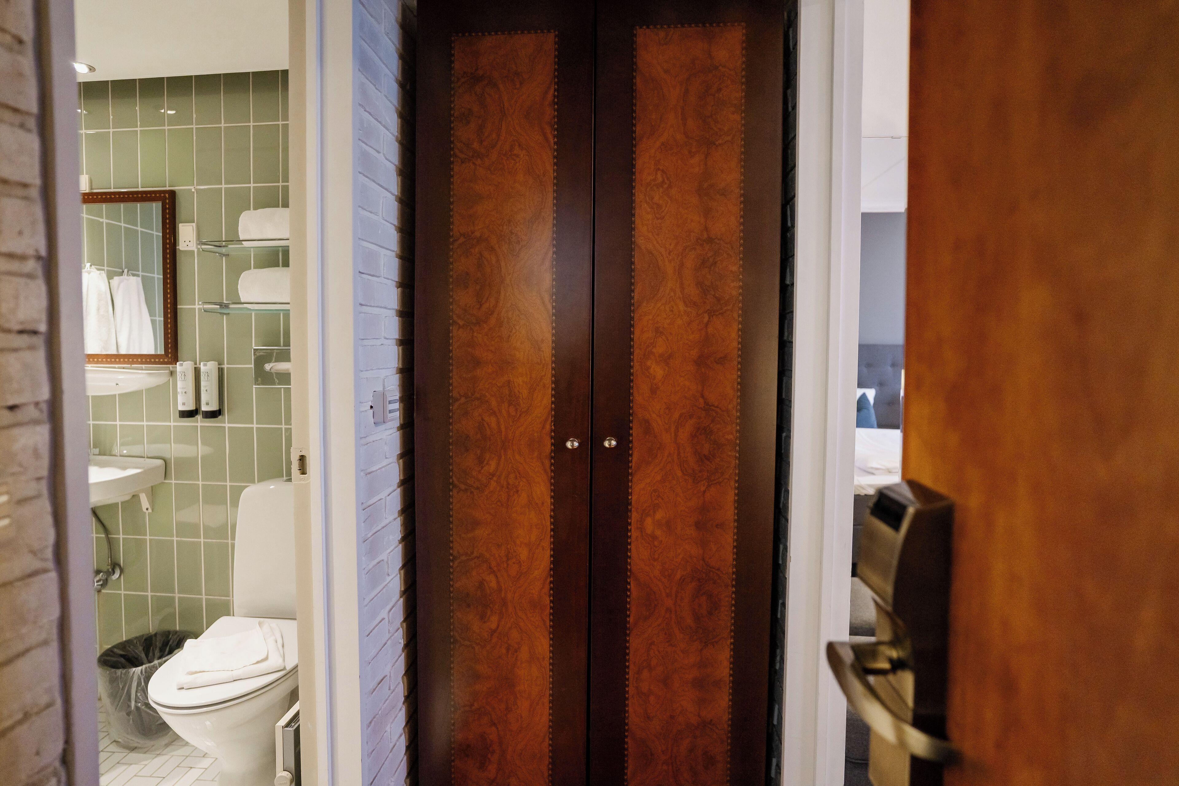 A bathroom with a toilet, sink, and mirror.