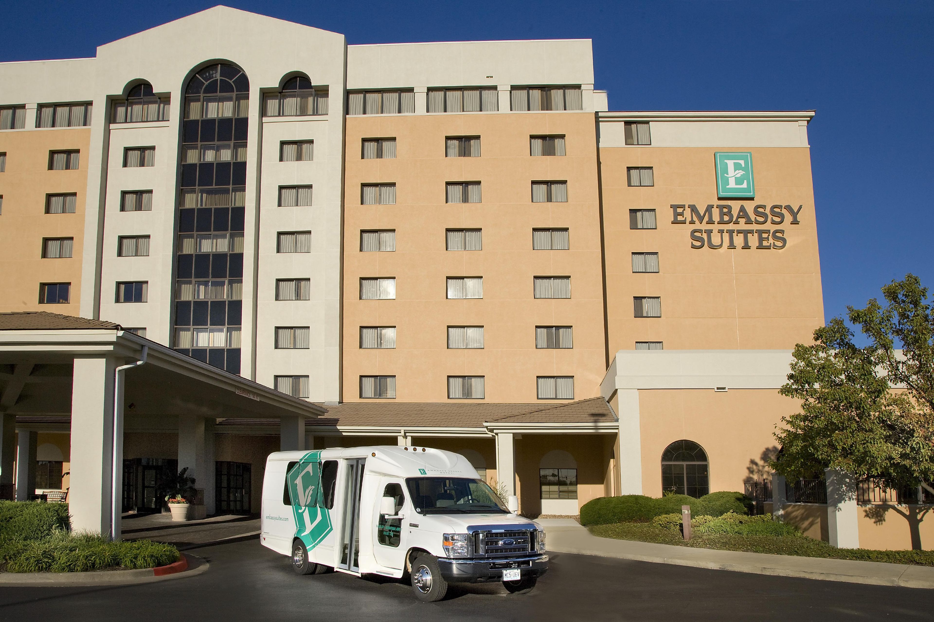 A multi-story building with a sign for 'Embassy Suites.'