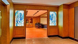 A hotel lobby with a grand piano, wooden paneling, and stained glass windows. - Wyndham Gatineau-Ottawa & Conference Centre (Gatineau)