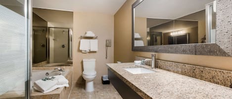 Een moderne badkamer met een grote spiegel, twee wastafels, een douche en een toilet.