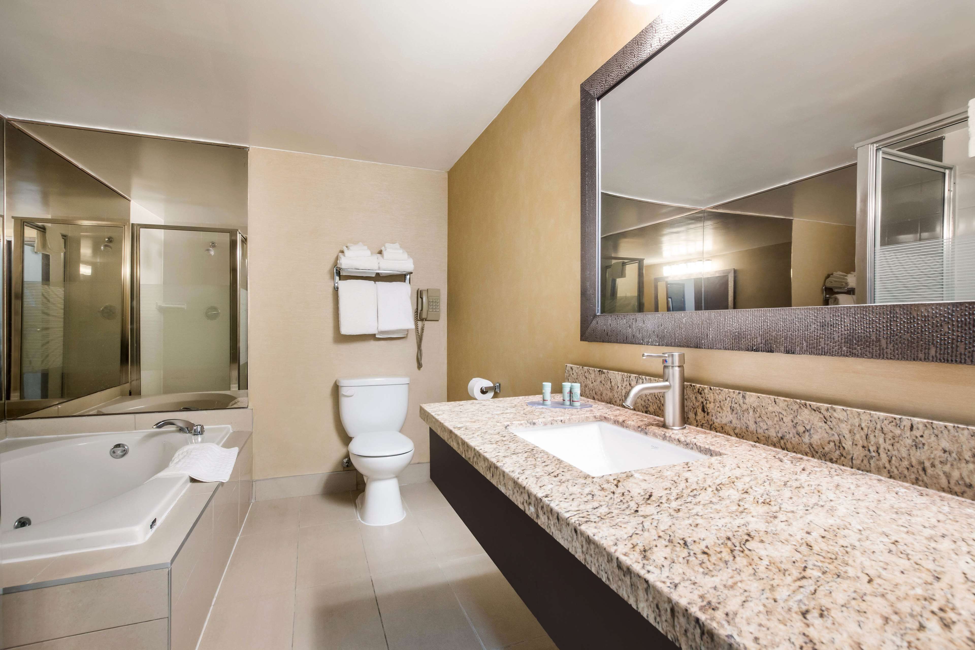 Ein modernes Badezimmer mit einer großen Badewanne, einer Toilette und einem Waschbecken.