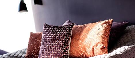 A bed with patterned pillows and a textured blanket.