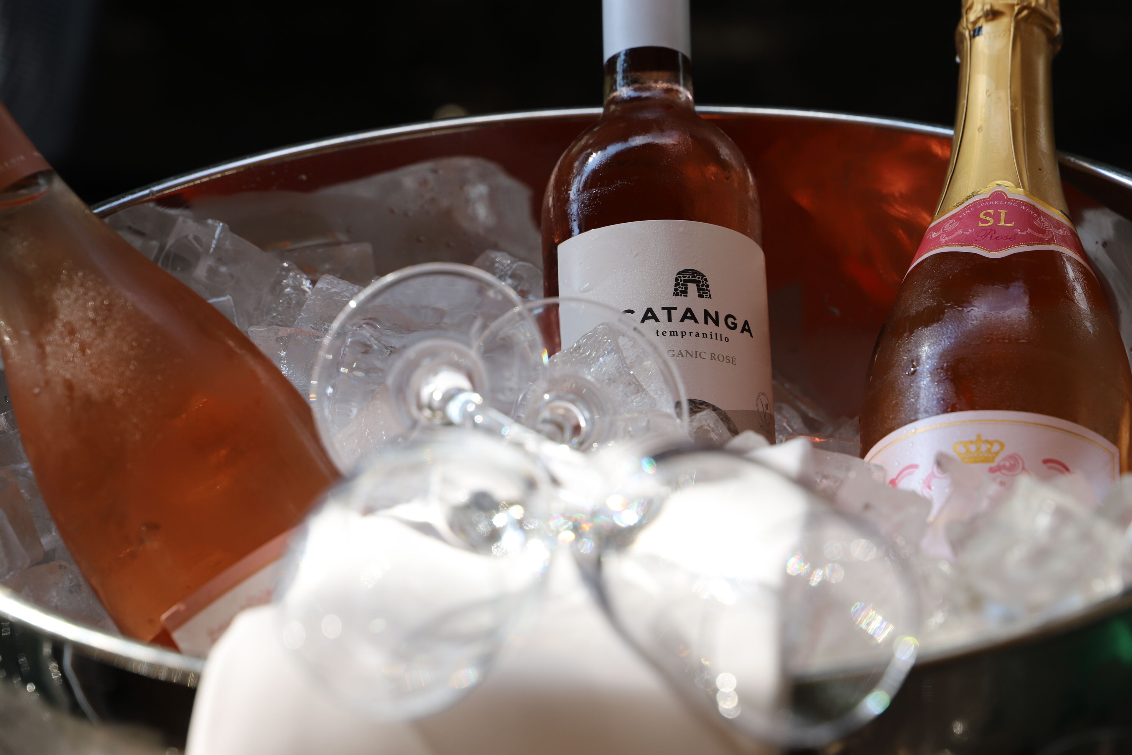 A bucket containing ice, a bottle of Catanga, and a bottle of champagne.