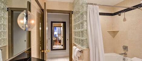 A modern bathroom with a glass shower enclosure, a bathtub, and a vanity with a mirror.