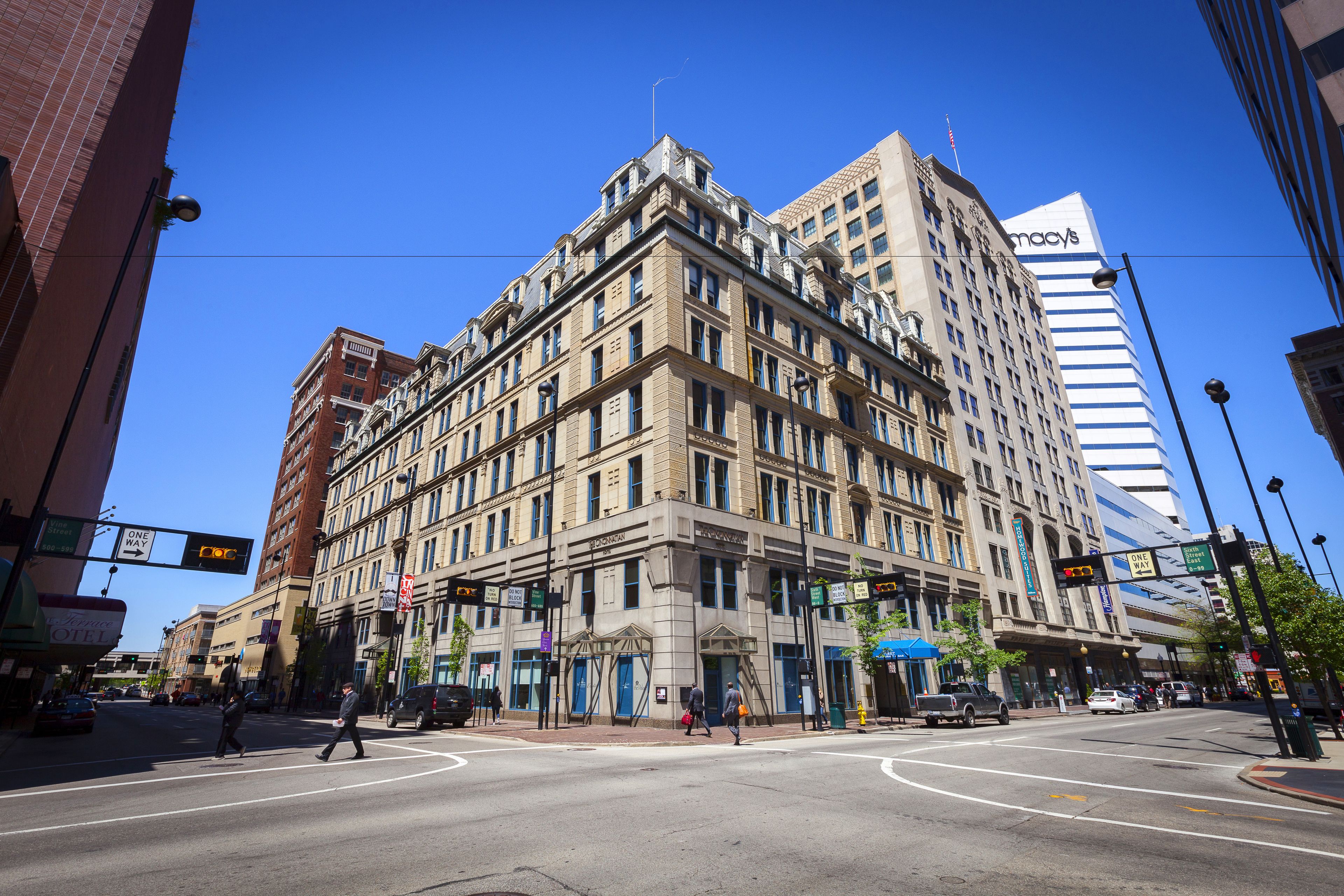 A multi-story building with a classic architectural style, featuring a prominent entrance with a blue awning and a large sign above the entrance.