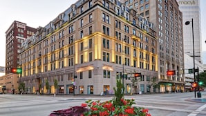 A multi-story hotel with a classic architectural design, featuring a prominent corner entrance and multiple windows. - The Cincinnatian Hotel Curio Collection by Hilton (Cincinnati)