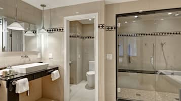 A modern bathroom with a glass-enclosed shower, a large sink, and a mirror above it.