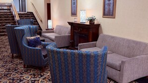 A living room with patterned armchairs, a sofa, a fireplace, and framed artwork on the walls. - Quality Inn Shenandoah Valley (New Market)