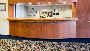 A reception desk with a wooden finish, a mirror, and a sign for 'Quality Inn' and 'My Choice Hotels'. - Quality Inn Shenandoah Valley (New Market)