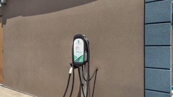 Uma estação de carregamento para veículos elétricos fixada em uma parede texturizada.
