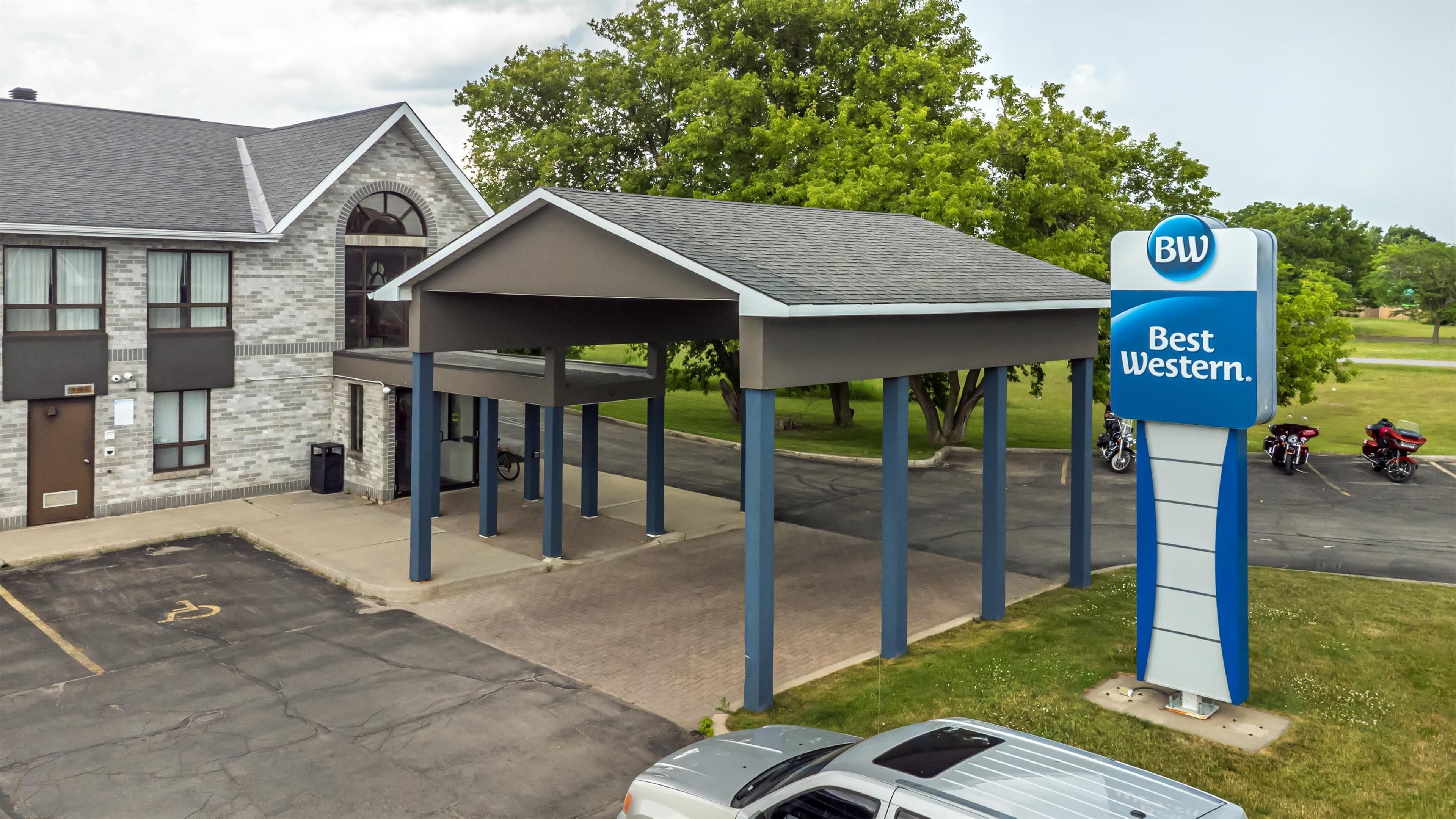 A Best Western hotel with a covered parking area, a brick building, and a signboard.