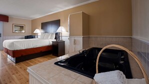 Habitación de hotel con cama, lámparas de noche, teléfono, bañera y un cuadro en la pared.