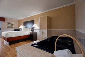Relax in this serene space with a large bed, a bedside table, and a spacious tub.