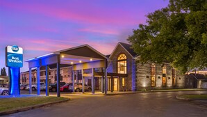 Un hotel Best Western con estacionamiento techado y un edificio de piedra con ventanas de arco.