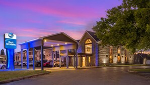 Un hotel Best Western con estacionamiento techado y un edificio de piedra con ventanas de arco.