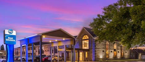 A Best Western hotel with a covered parking area and a stone building with arched windows.