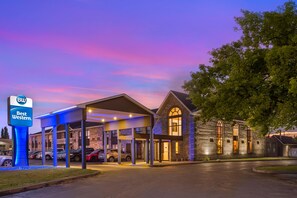 A Best Western hotel with a covered parking area and a stone building with arched windows. - Best Western Smiths Falls Hotel (Smiths Falls)