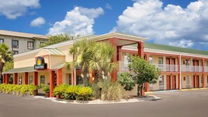 Ein Motel mit Innenhof, Palmen und blauem Himmel.