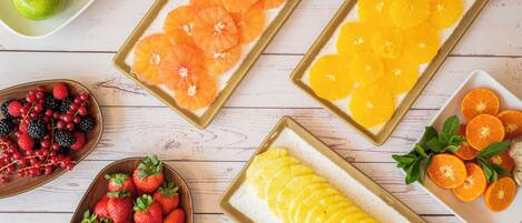 A variety of fruits arranged on trays and bowls.