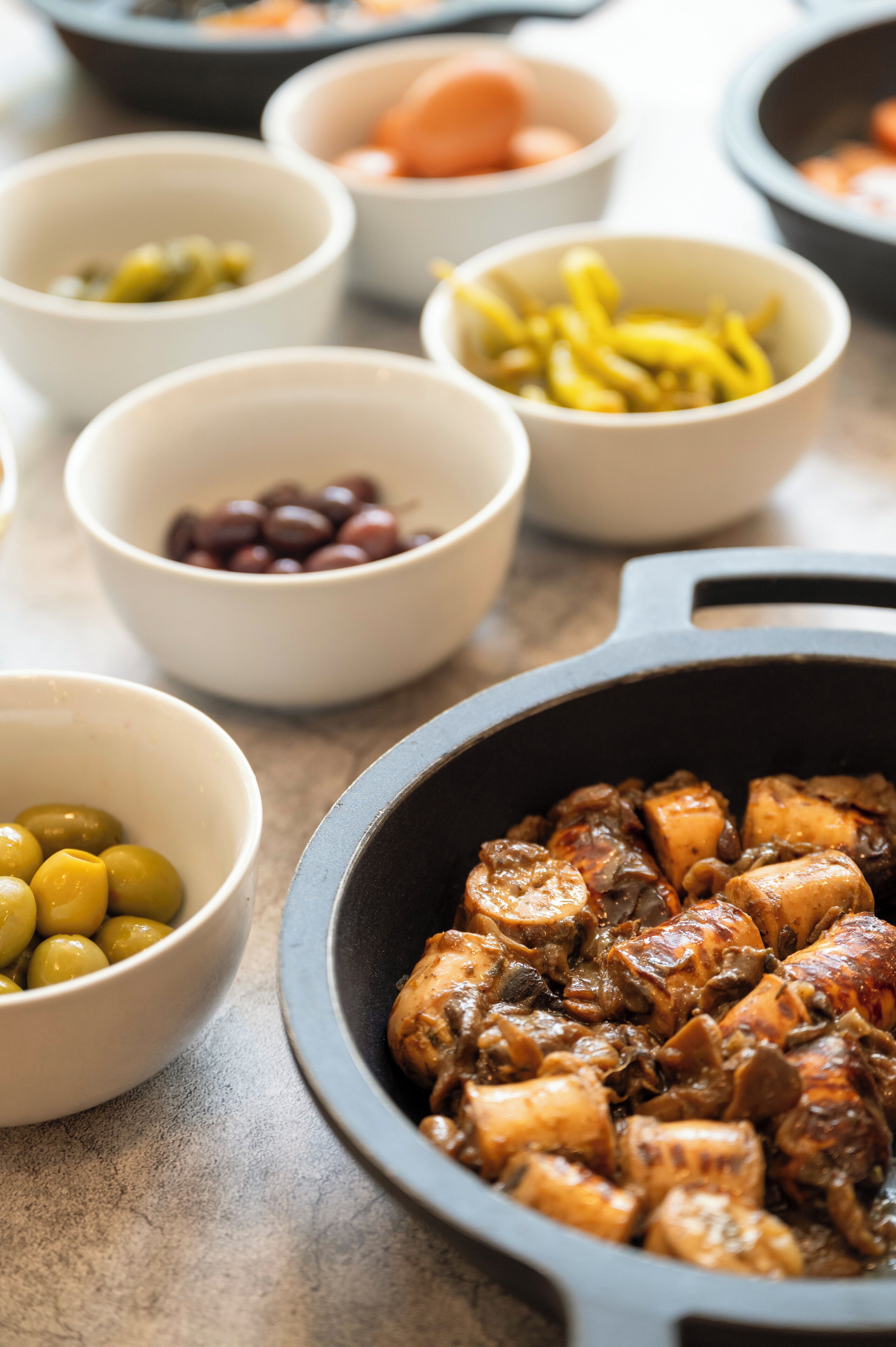 A variety of food items in bowls and a cast iron skillet.