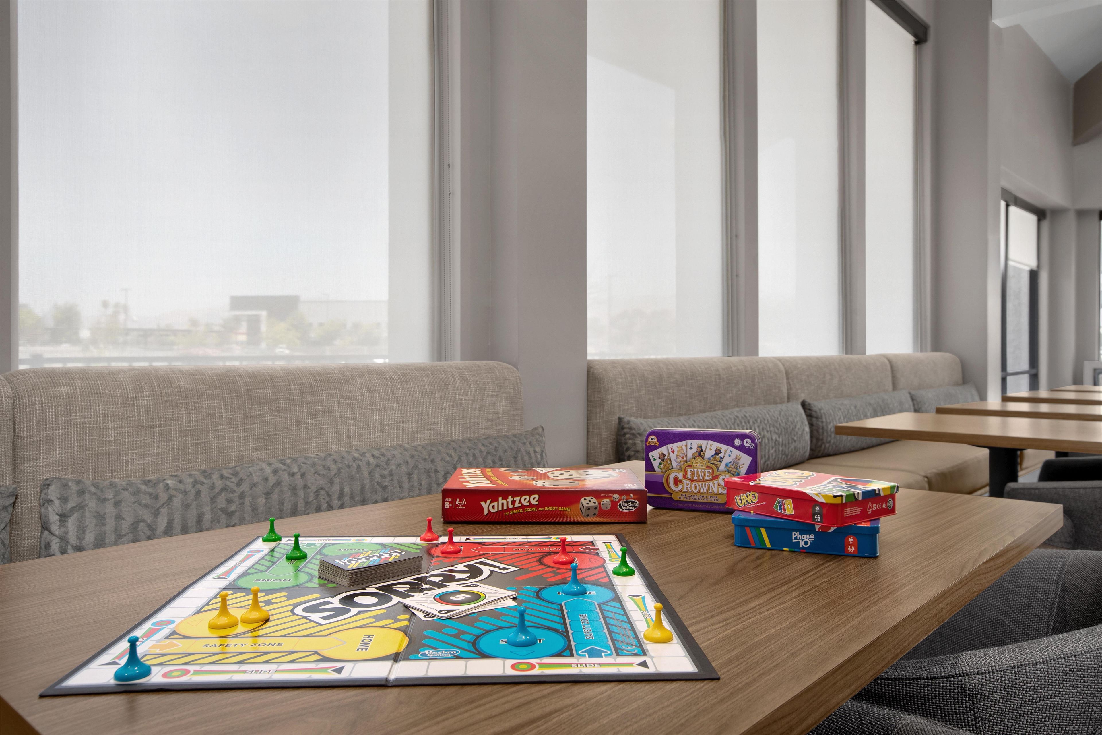 A board game setup on a table with a sofa and a window in the background.