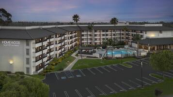 A hotel with multiple floors, a swimming pool, and a parking lot.