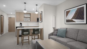 Una cocina moderna con comedor, sofá y cafetera.
