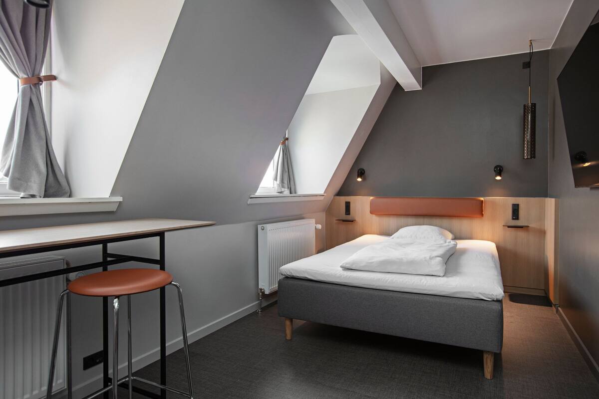 Ein modernes Schlafzimmer mit Bett, Schreibtisch und Stuhl.