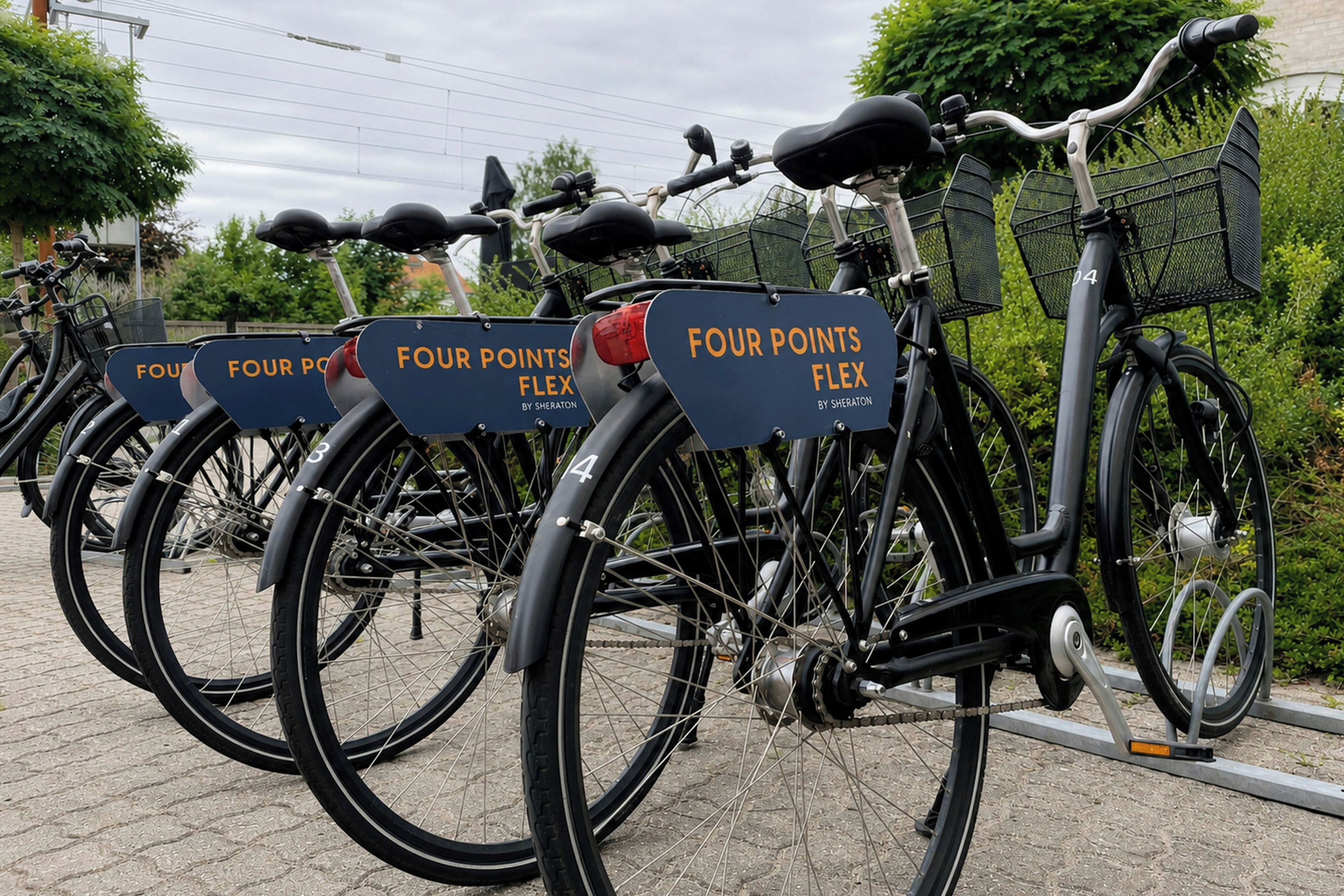 Diverses bicicletes amb indicadors de 'FOUR POINTS FLEX', aparcades sobre una superfície pavimentada.