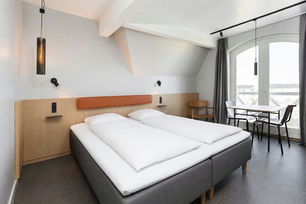 A hotel room with a bed, a desk, and a chair. - Four Points Flex by Sheraton Køge (Koge)