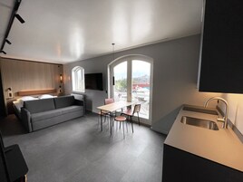 Una cocina moderna con comedor, un sofá y un ventanal con vistas a la ciudad.