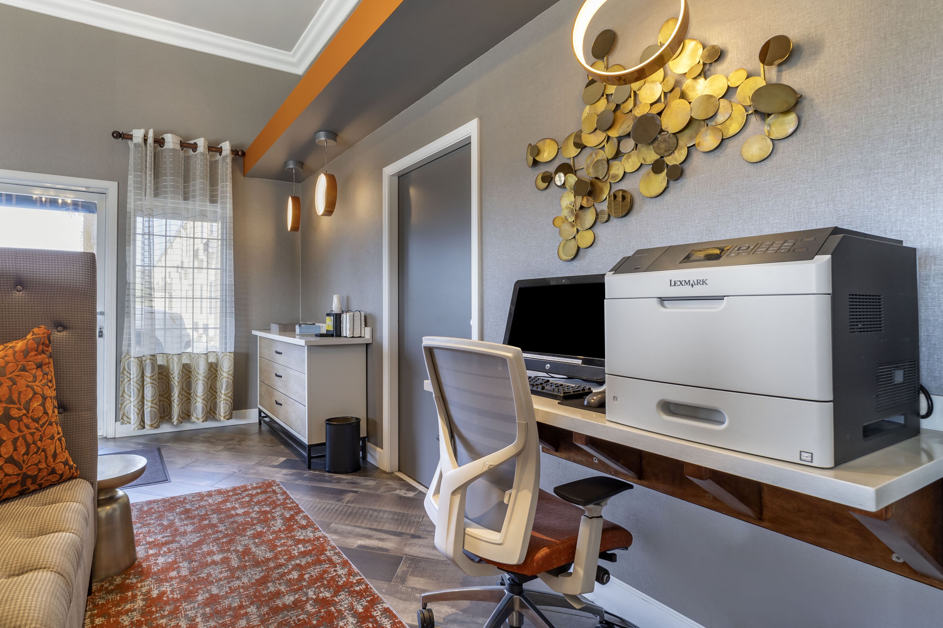 A modern office space with a printer, office chair, and desk.