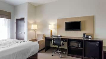 A hotel room with a bed, desk, chair, TV, and a coffee maker.