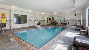 An indoor swimming pool with a lifeguard chair, a changing room, and a reception area with a counter and chairs. - Sleep Inn & Suites Cave City (Cave City)