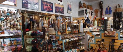 A well-lit store with various items on display including bags, jewelry, and pottery.