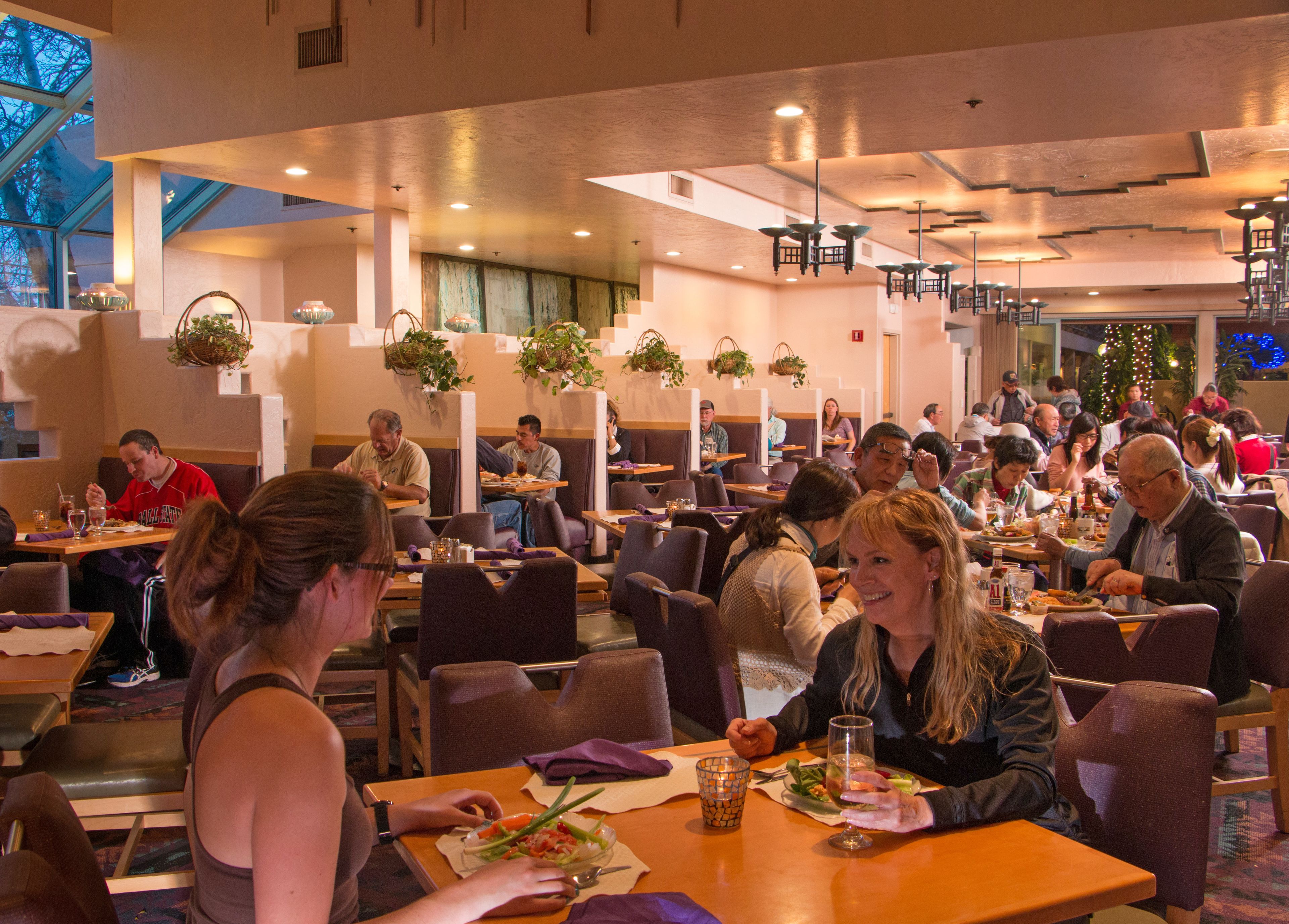 Un restaurante con varias zonas de comedor, mesas y sillas.