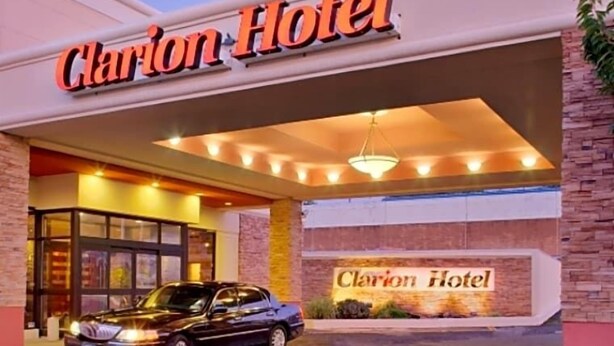 The Clarion Hotel entrance with a car parked in front. - The Landing at Laguardia (East Elmhurst)