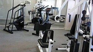 A gym with treadmills, weight machines, and a mirrored wall. - The Landing at Laguardia (East Elmhurst)