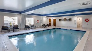 An indoor swimming pool with a blue and white color scheme, seating areas, and informational signs on the walls. - Days Inn by Wyndham St. Louis Lindbergh Boulevard (St. Louis)