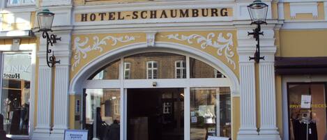 A hotel entrance with a sign reading "HOTEL-SCHAUMBURG".