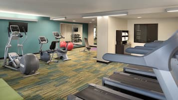 A hotel fitness center with treadmills, elliptical machines, and exercise balls.