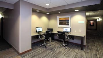 A conference room with two desks, chairs, and computers.