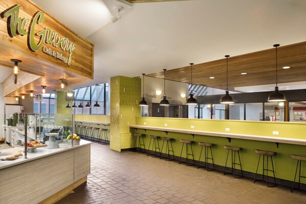 A bakery with a wooden ceiling, a counter with a display case, and bar stools. - Holiday Inn & Suites Duluth Downtown by IHG (Duluth)